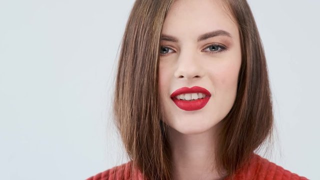 Closeup face of a sexy caucasian girl sending a kiss. Portrait of a beautiful young woman with a sexy pouting lips. Stunning girl is flirting.  Sensual fashion model.