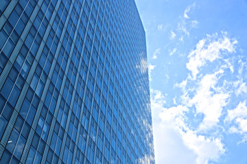 ガラス張りのオフィスビルと青空
