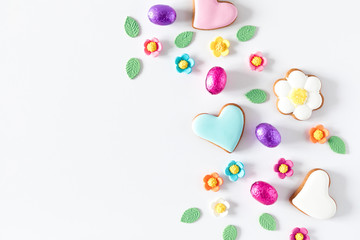 Easter composition. Easter eggs, cookies, sweets, decorations on white background. Flat lay, top view, copy space