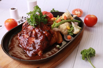 Grilled chicken with sauce on stone plate. 
