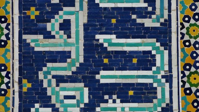 Handheld, tilting, close up shot of a lined design made of tiles on a wall. 