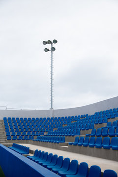 Tennis Court, empty blue seats.