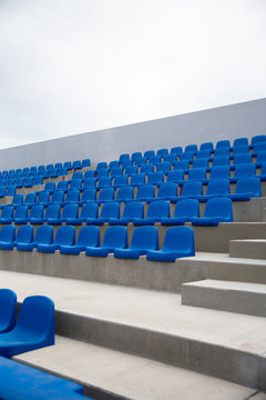 Tennis Court, empty blue seats.