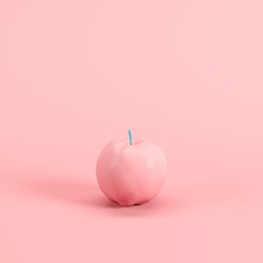 Apple painted in pink with blue stem isolated on pastel pink backgound. Minimal fruit idea concept.