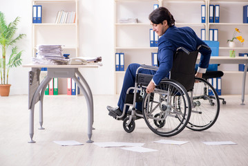 Young male employee in wheelchair working in the office 