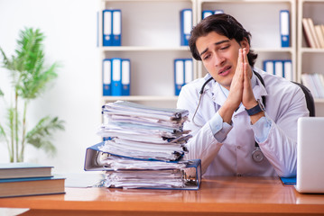 Young handsome doctor working in the clinic 