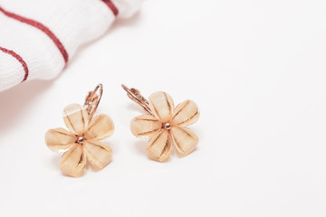 Fototapeta na wymiar A pair of cristal flower form bijouterie earrings on white background with copy space