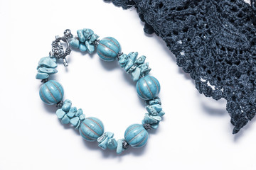 Natural turquoise bracelet with silver lock and black fabric textyle lace on white background, beautiful blue bijouterie for woman