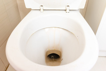 Dirty unhygienic toilet bowl with limescale stain at public restroom close up