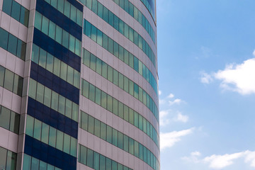 green windows of a modern building against the blue sky