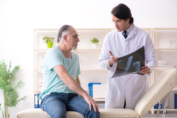 Fototapeta premium Old man visiting young male doctor 
