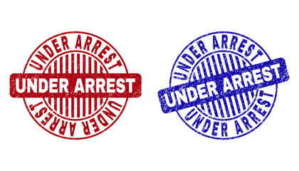 Grunge UNDER ARREST round stamp seals isolated on a white background. Round seals with grunge texture in red and blue colors.