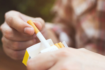 close up man hand holding peel it off cigarette pack prepare smoking a cigarette. Packing line up....