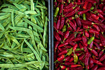 Green peas and chilli peppers in boxes on the street market