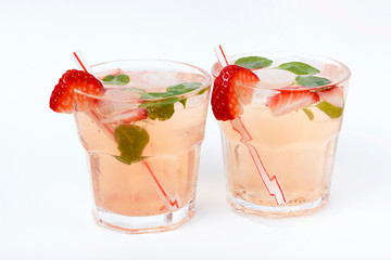 Cold summer drink with ice and strawberries on a white background