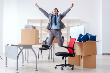 Young man employee with boxes in the office 