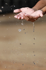 Fototapeta na wymiar Water Pouring in Child's Hands