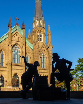 St. Dunstan's Basilica Cathedral, National Historic Site of Canada, and the bronze statue of two Fathers of Confederation in the sunny day in Charlottetown, Prince Edward Island
