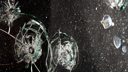 broken cracked glass with hole over black background