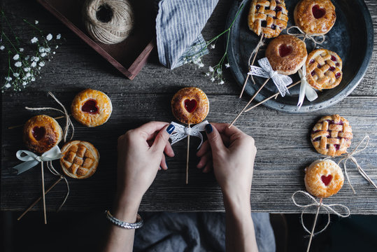 Overhead view of women tying a bow to pie pops