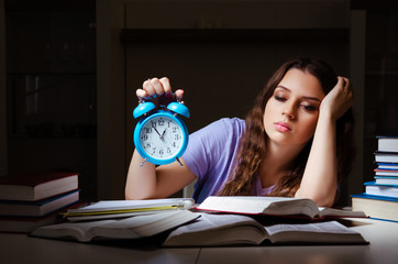 Young female student preparing for exams late at home 