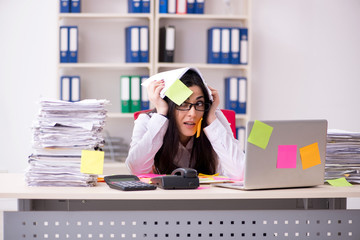 Young female employee in conflicting priorities concept 