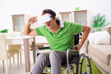 Young handsome man in wheelchair at home 