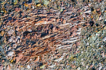 Brown stone wall rock texture background close-up.