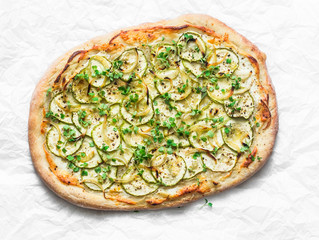 Vegetarian zucchini micro greens and vegetarian cheese flatbread on light background, top view