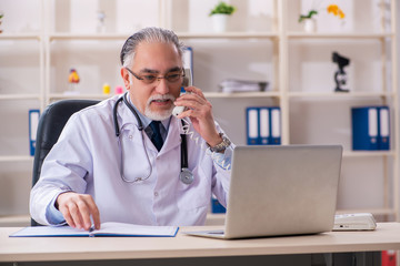 Aged male doctor working in the clinic 