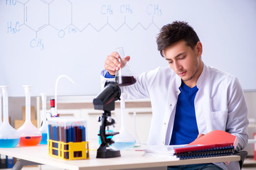 Young chemist sitting in the lab 