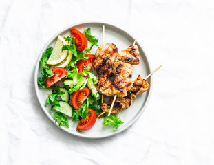 Turkey skewers and vegetables fresh salad on a light background, top view