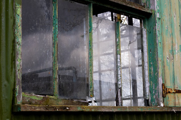 Dilapidated wooden window frame on condemned derelict factory building awaiting demolition 