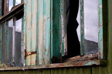 Dilapidated wooden window frame on condemned derelict factory building awaiting demolition 