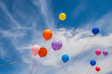 Colorful balloons floating free in a cloudy sky