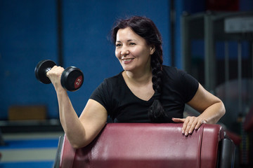 Senior woman in gym working out with dumbbells. close-up. copy space.