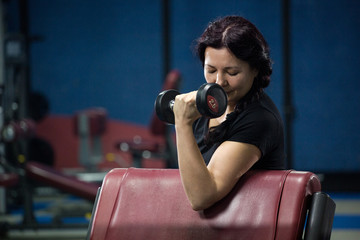 Senior woman in gym working out with dumbbells. close-up. copy space.
