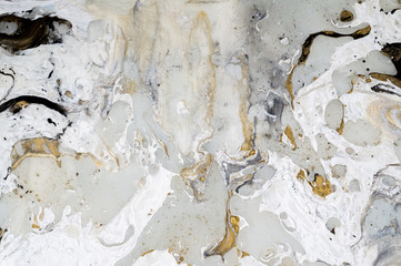 Marble background texture with gold, black, grey and white colors, using acrylic pouring medium art technique. Useful as a backdrop or background, or copy space. Beautiful paint splatter abstract art.