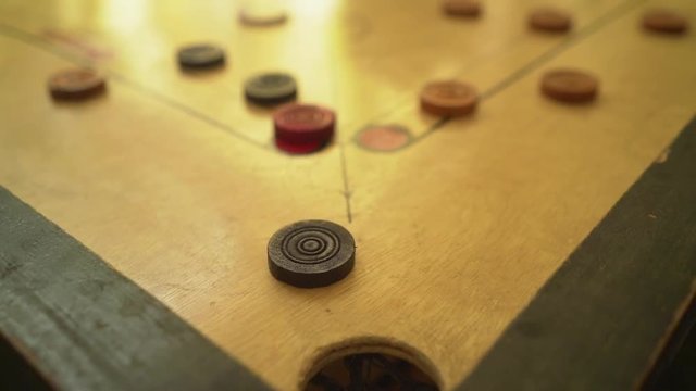 a game of carom with pieces, trying to score ,Carrom board game, slow motion