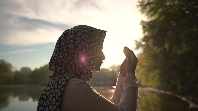 Atlanta, USA - April 1,2019: Moslem woman praying outdoor early morning while sunrise.