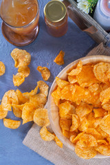 Flat lay of Crispy potato chips on wooden bowl