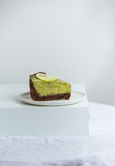 Vegan healthy No-bake avocado lime cheesecake on white background with copy space