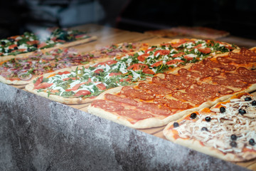 pizza for sale, slice of pizza behind display window  -