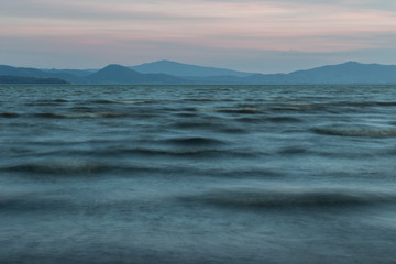 Close view of moving waves on a lake at dusk