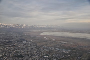 Aerial view from airplane of Antelope Island at sunset, view from Magna, sweeping cloudscape at sunrise with the Great Salt Lake State Park in winter. USA, Utah.