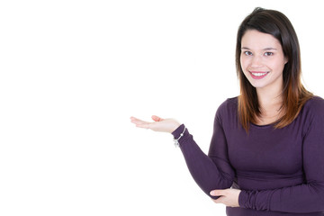 Young businesswoman in purple sweater showing something in white copy space