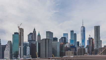 Fototapeta na wymiar Skyscrapers of downtown Manhattan under clouds and sky viewed from Brooklyn Bridge Park, in Brooklyn, New York, USA