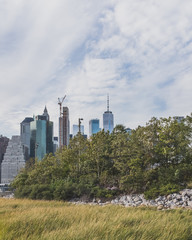 Fototapeta na wymiar Skyscrapers of Manhattan over trees of Brooklyn Bridge Park, in Brooklyn, New York, USA