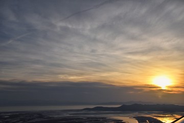 Aerial view from airplane of Antelope Island at sunset, view from Magna, sweeping cloudscape at sunrise with the Great Salt Lake State Park in winter. USA, Utah.