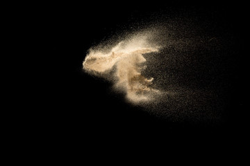 Fototapeta na wymiar Sand explosion isolated on black background. Freeze motion of sandy dust splashing.